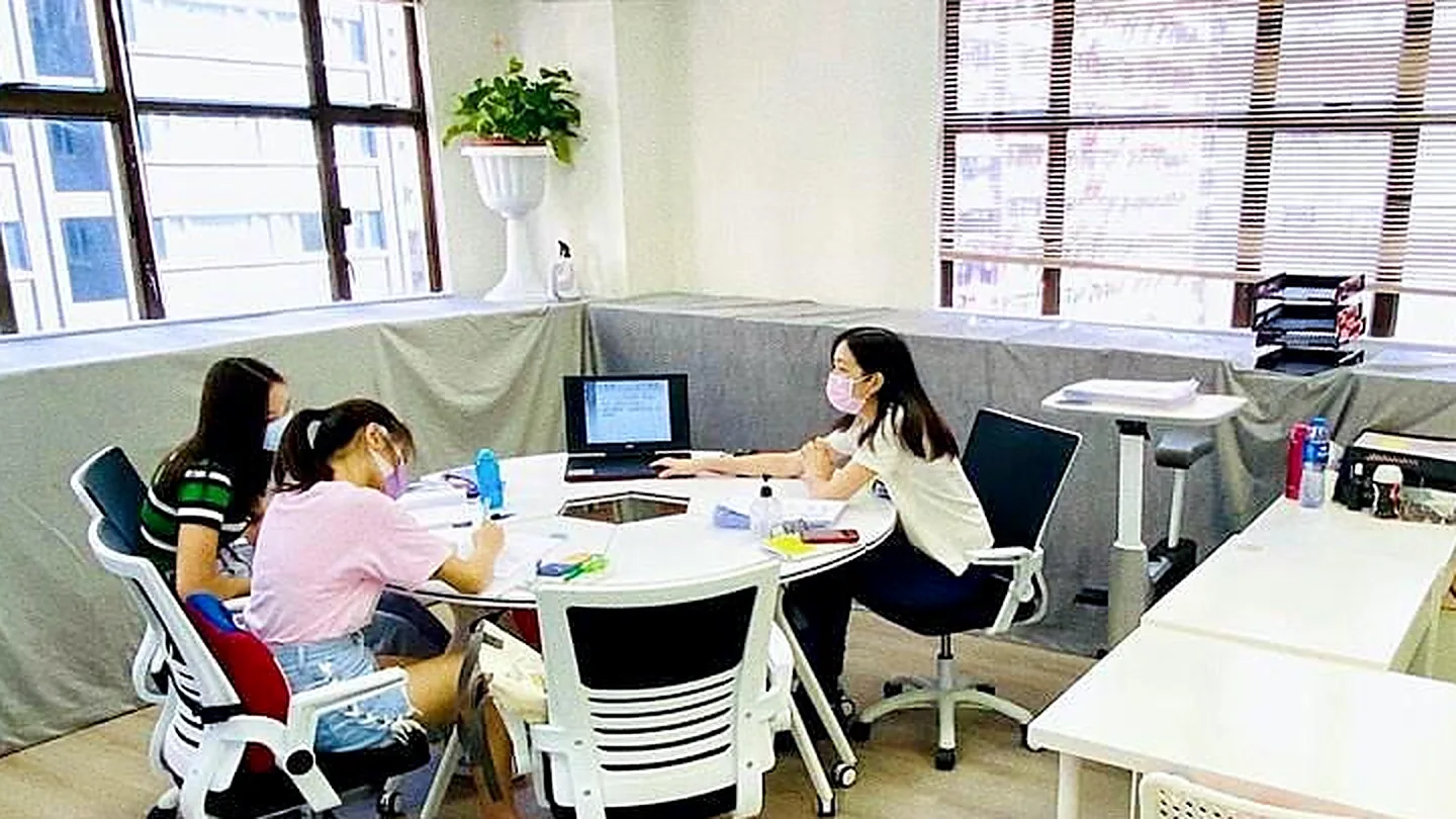 補習中心的小組課堂，學生圍著圓桌跟老師上課